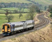 Class 158 train travels through the picturesque countryside